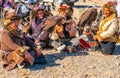 ULGII, MONGOLIA - OCTOBER 6, 2018 : Golden Eagle Festival. Kazakh eagle hunters in traditional clothing sat on the floor waiting