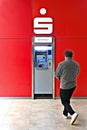 Ulm, Germany - June, 16, 2023: Unrecognizable person is getting cash from ATM of Sparkasse Ulm.