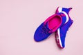 Ultra blue violet pink female sneakers on pastel pink background flat lay top view with copy space. Sports shoes, fitness, concept