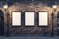 Three blank billboards on an old brick wall illuminated by street lamps Royalty Free Stock Photo