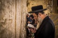 The ultra-orthodox Jewish man (haredi) praying with Tora in hand at Western wall (Wailing Wall) at Jerusalem. Royalty Free Stock Photo