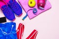Ultra violet female sneakers, pink top blue sporting leggings and water bottle on pastel pink background flat lay top view with co Royalty Free Stock Photo