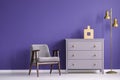 Ultra violet living room interior with retro armchair and chest