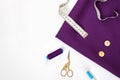 Sewing accessories on violet fabtic and white copy space Royalty Free Stock Photo