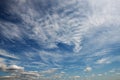 Ultra wide angle shot of white scattered clouds floating away overhead in blue vibrant sky