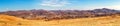 Ultra wide panorama of grassland with city homes and hills in the background Royalty Free Stock Photo