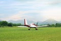 Ultralight aircraft on green grass near trees Royalty Free Stock Photo