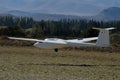 Ultralight glider plane flying near mountains, landing on earth aerodrome