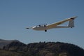 Ultralight glider plane flying near mountains, landing on earth aerodrome