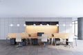 An ultramodern office interior with sleek furniture, computers on desks, and ambient overhead lighting on a wood and metal Royalty Free Stock Photo