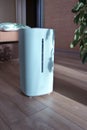 Ultrasonic Air humidifier in the interior. Blue humidifying device on the wooden floor with a falling shadow. Air Moisture Equipme