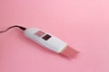 Ultrasonic peeling device with two modes with black cable on pink background