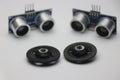 Ultrasonic sensor use to make various range measuring projects on white background with wheels that shows robotic projects concept