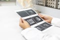 Ultrasound of baby in pregnant woman, Doctor reading test results of pregnant woman by ultrasound. Royalty Free Stock Photo