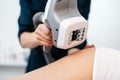 Ultrasound cavitation mashine in the hands of beautician. Close-up view. Woman is receiving the anti-cellulite treatment