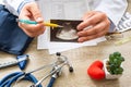 Ultrasound examination concept photo. Doctor during consultation held in his hand and show to patient printout picture of ultrasou