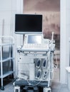 Ultrasound machine with buttons, sensors and monitors. Modern white gray medical equipment in light interior of doctors office Royalty Free Stock Photo