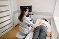 Ultrasound in physical therapy. Young woman therapist using ultrasound scanner on female patient lower back. Back and