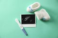 Ultrasound picture, baby shoes and pregnancy test on color background Royalty Free Stock Photo
