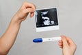 Ultrasound picture and positive pregnancy test in the hands of a girl Royalty Free Stock Photo