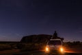 Uluru at night with car with a young man on the car, ayers Rock, the Red Center of Australia, Australia