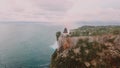 Uluwatu cliff with crystal blue water and gold beach in Indonesia. Bali landscape from top view from a mountain peak. Travel parad