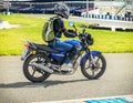 Ulyanovsk, Russia - June 10, 2017. Girl in a black jacket race on a blue motorcycle on a sports track.