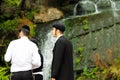 Uman,Ukraine. Boys, a family of Hasidic Jews, stand in front of a waterfall in the park in Uman, Ukraine, the time of