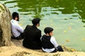 Uman,Ukraine. A family of Hasidic Jews, 3 boys, in traditional black clothes sitting in the autumn park,