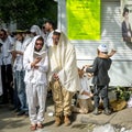 Rosh Hashanah, Jewish New Year. Mass prayer of pilgrims of Hasidim on the street. Hasid kids blows Shofar.