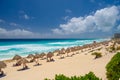 Umbrelas on a sandy beach with azure water on a sunny day near Cancun, Mexico Royalty Free Stock Photo