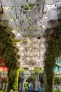 Umbrella-covered decorative alley on the territory of the botanical Dubai Miracle Garden in Dubai city, United Arab Emirates