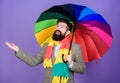 An umbrella is needed on a rainy day. Autistic or rain man holding colorful umbrella. Autism. Bearded man checking if it