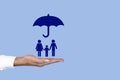Umbrella over the concept of family for protection, safety, finance and insurance on a female palm. Copy space Royalty Free Stock Photo