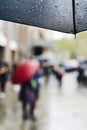 Umbrella and people walking under the rain