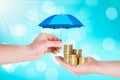 Umbrella protection coins hand man holding stack of money savings a business. Protection money concept Royalty Free Stock Photo