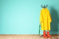 Umbrella, rain coat and boots near color wall Royalty Free Stock Photo