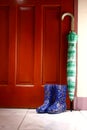 Umbrella and rubber or rain boots by the door Royalty Free Stock Photo