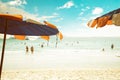 An umbrella at tropical beach with blurred people relaxing on beach in summer. Royalty Free Stock Photo