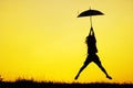 Umbrella woman jump and sunset silhouette Royalty Free Stock Photo