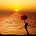 Umbrella woman jump and sunset silhouette Royalty Free Stock Photo