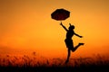 Umbrella woman jumping and sunset silhouette Royalty Free Stock Photo