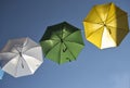 Umbrellas of different colors over the street with blue sky as background Royalty Free Stock Photo