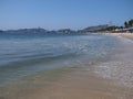 Umbrellas and exotic palms on sandy beach at beauty bay of Acapulco city landscape with waves of Pacific Ocean in Mexico Royalty Free Stock Photo