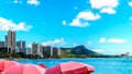 Umbrellas galore at Waikiki Beach with its many resorts under blue sky