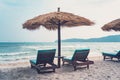 Umbrellas made of straw and chaise longue made of wood on a wonderful tropical beach, Beautiful beach, azure sea and white sand,