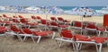 Umbrellas and orange chairs on the beach near the sea