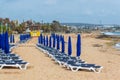 Umbrellas and sun loungers on the sandy beach at the beginning of the season. Ayia NAPA, Cyprus Royalty Free Stock Photo