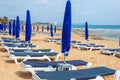 Umbrellas and sun loungers on the sandy beach at the beginning of the season. Ayia NAPA, Cyprus Royalty Free Stock Photo