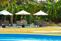 Umbrellas and sunbeds on the pool. A quiet place at a resort in the tropics. Place for sunbathing and lying.